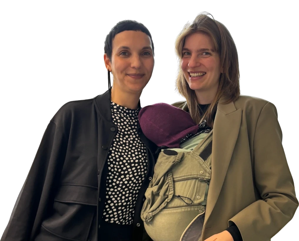 Jackie und Charlotte nebeneinander, Charlotte trägt ihr Baby in der Trage